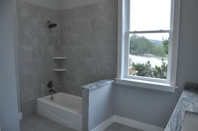 bathroom with tiled shower / bath combo and vanity