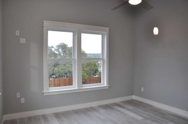 unfurnished room featuring ceiling fan, a healthy amount of sunlight, and light hardwood / wood-style floors