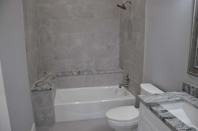 full bathroom with tiled shower / bath, toilet, tile flooring, and vanity