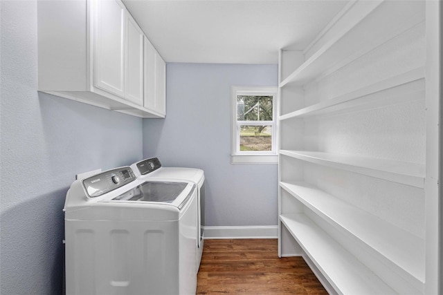 laundry area with washing machine and clothes dryer, dark hardwood / wood-style floors, and cabinets