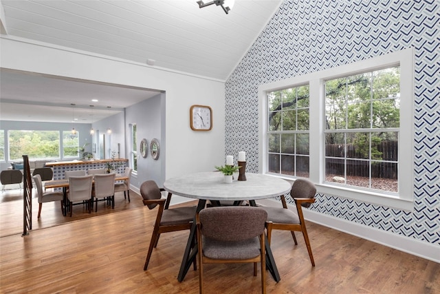 dining space featuring an inviting chandelier, high vaulted ceiling, and light wood-type flooring