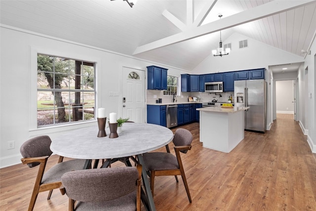 dining space with high vaulted ceiling, a chandelier, beamed ceiling, and light hardwood / wood-style floors