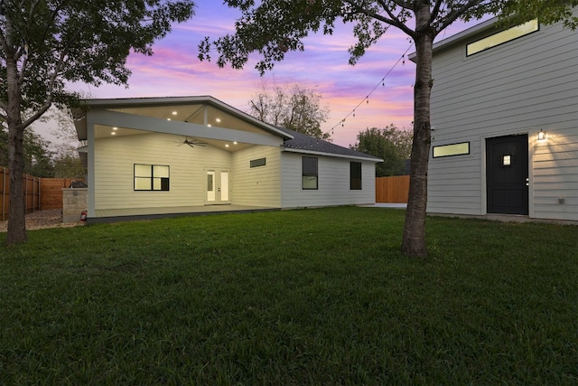 back house at dusk with a yard