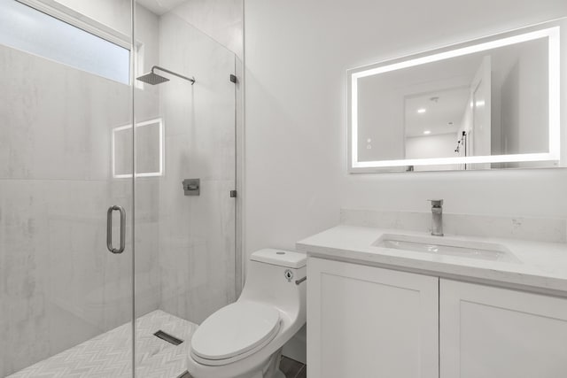 bathroom featuring a shower with door, toilet, and vanity