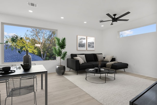 living room with ceiling fan and light hardwood / wood-style flooring