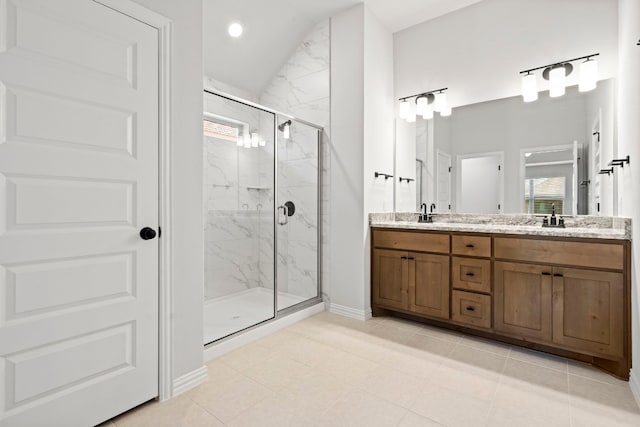 bathroom featuring an enclosed shower, double sink, vanity with extensive cabinet space, and tile flooring