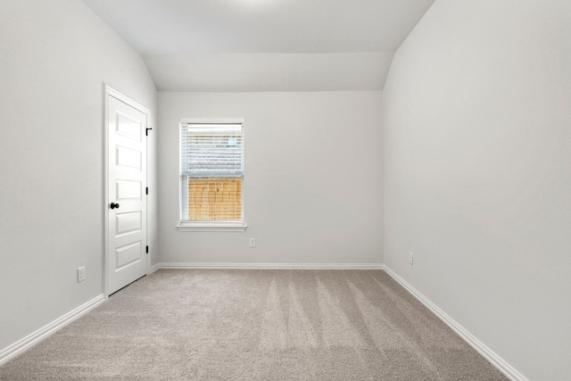 empty room with light carpet and vaulted ceiling