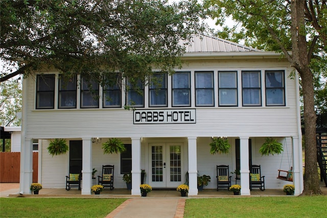 back of property featuring a lawn and covered porch