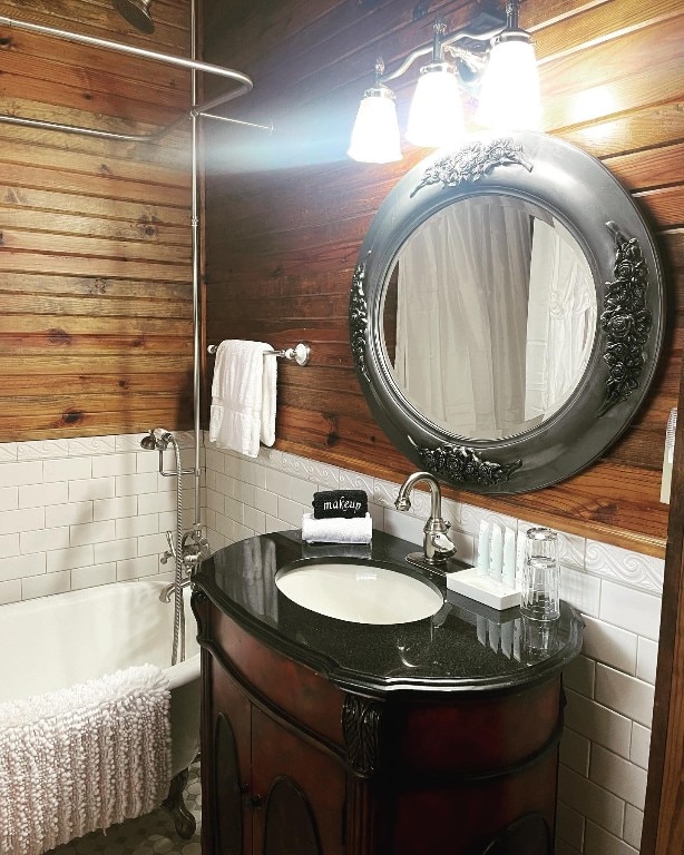 bathroom with wooden walls, tile walls, and vanity