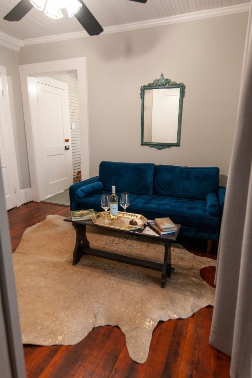 living room featuring dark wood-type flooring, ceiling fan, and crown molding