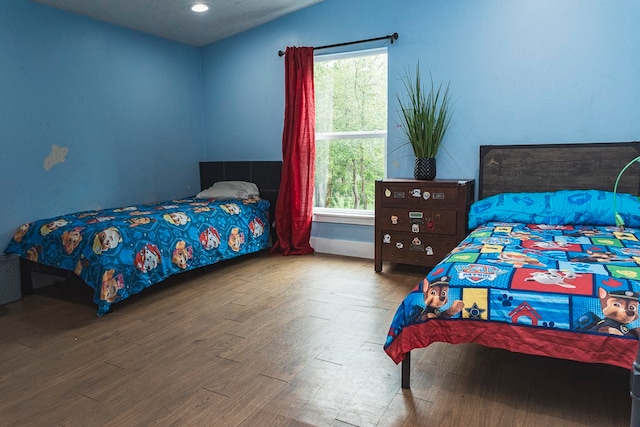 bedroom with lofted ceiling, light hardwood / wood-style floors, and multiple windows