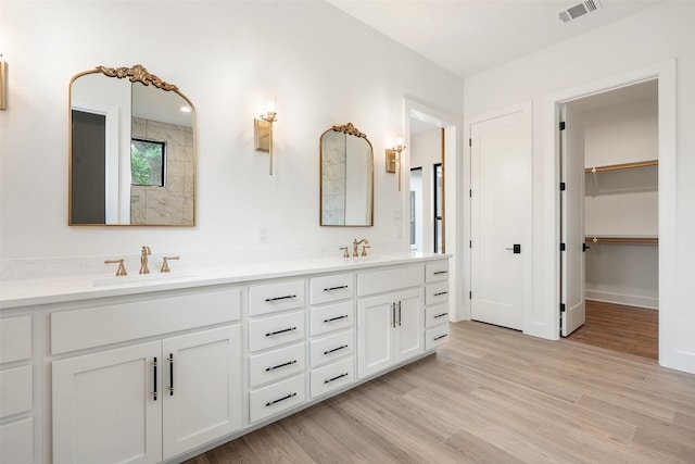 bathroom featuring double sink, wood-type flooring, and oversized vanity