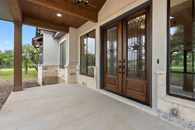 view of exterior entry with a patio area and french doors