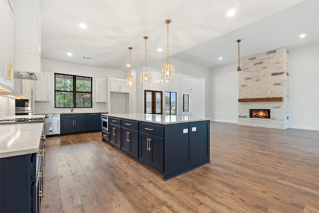 kitchen with backsplash, pendant lighting, dark wood-type flooring, and white cabinets