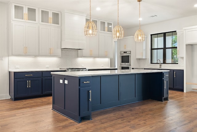 kitchen with white cabinets, premium range hood, dark hardwood / wood-style flooring, and decorative light fixtures