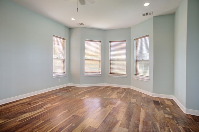 spare room featuring dark hardwood / wood-style flooring, a wealth of natural light, and ceiling fan