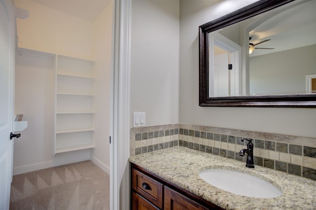 bathroom with ceiling fan, vanity, and decorative backsplash