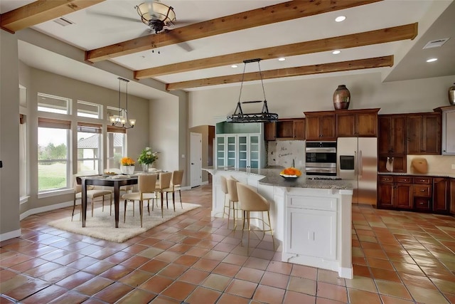 kitchen featuring light tile patterned floors, tasteful backsplash, visible vents, appliances with stainless steel finishes, and beam ceiling