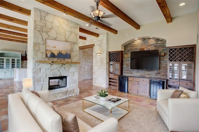 living room featuring bar, a fireplace, beam ceiling, and light tile patterned floors