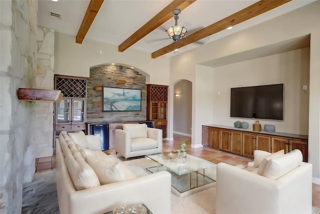 living room with arched walkways, a bar, beam ceiling, and visible vents