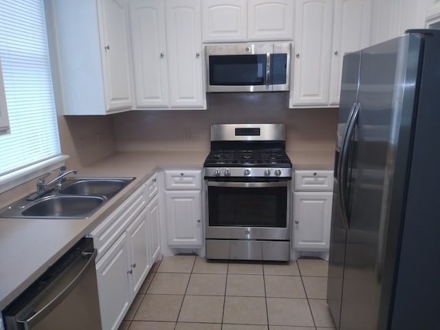 kitchen featuring appliances with stainless steel finishes, white cabinetry, and sink