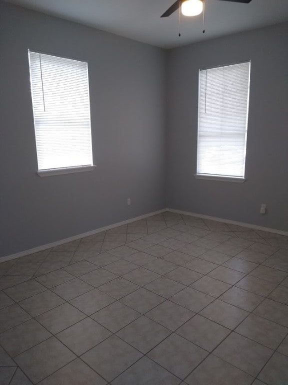 unfurnished room with tile floors and ceiling fan