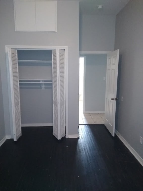 unfurnished bedroom with a closet and dark hardwood / wood-style flooring