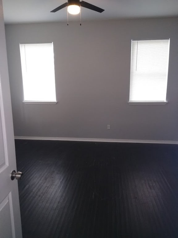 empty room featuring ceiling fan and dark hardwood / wood-style flooring