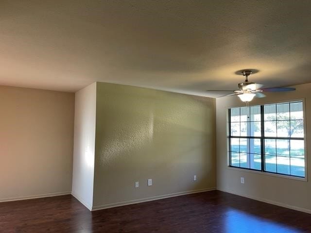 spare room with dark hardwood / wood-style floors and ceiling fan