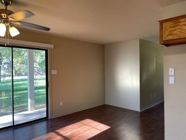 empty room featuring dark hardwood / wood-style flooring and ceiling fan