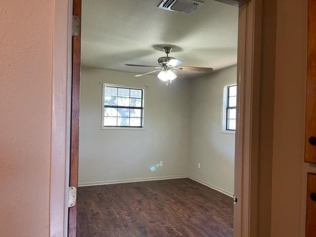 empty room featuring ceiling fan and dark hardwood / wood-style flooring