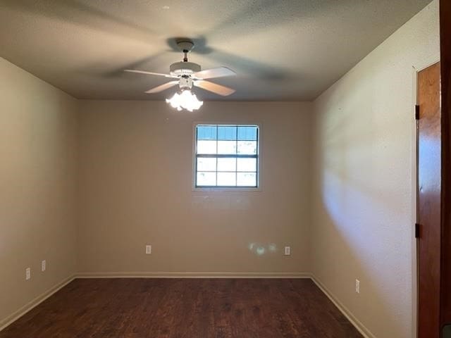 spare room with dark hardwood / wood-style flooring and ceiling fan