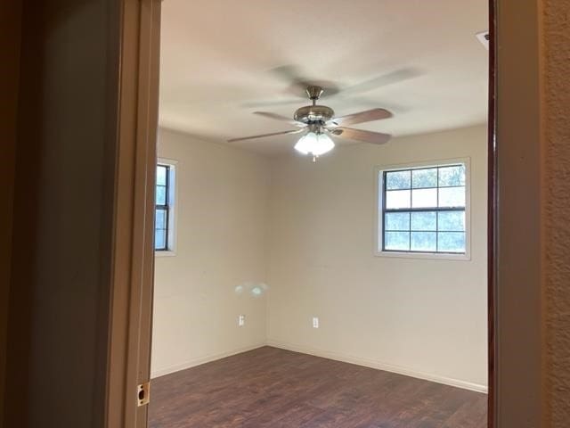 unfurnished room with ceiling fan and dark wood-type flooring