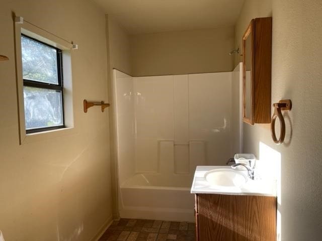 bathroom featuring shower / washtub combination, plenty of natural light, tile floors, and vanity