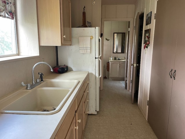 kitchen with sink, light brown cabinetry, light tile flooring, and white refrigerator