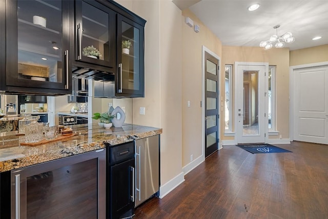 bar featuring pendant lighting, beverage cooler, baseboards, and dark wood-style flooring