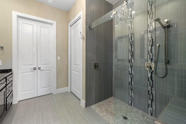 bathroom featuring vanity, baseboards, and walk in shower