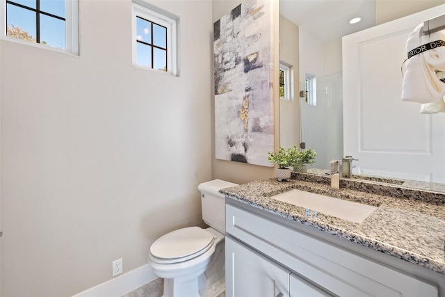 bathroom featuring recessed lighting, toilet, a shower stall, vanity, and baseboards