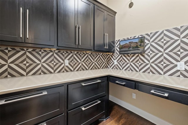 kitchen with dark wood-style floors, light countertops, and decorative backsplash