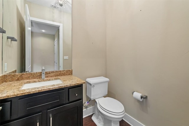 bathroom with toilet, baseboards, and vanity