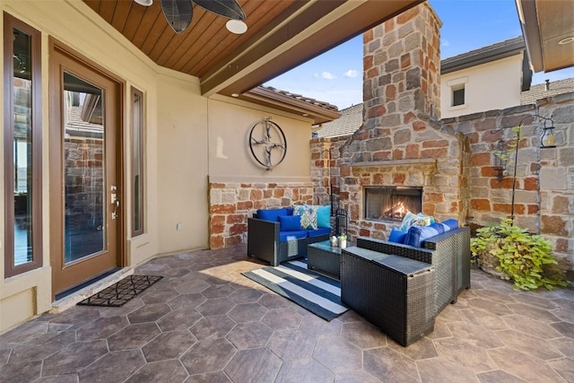 view of patio featuring a ceiling fan and an outdoor living space with a fireplace