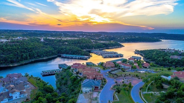 aerial view at dusk featuring a water view