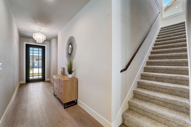 foyer entrance with a chandelier and light wood-type flooring