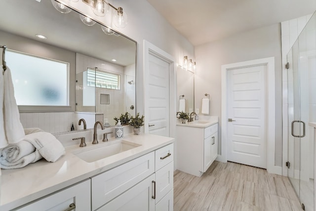 bathroom featuring hardwood / wood-style flooring, vanity, and a shower with door