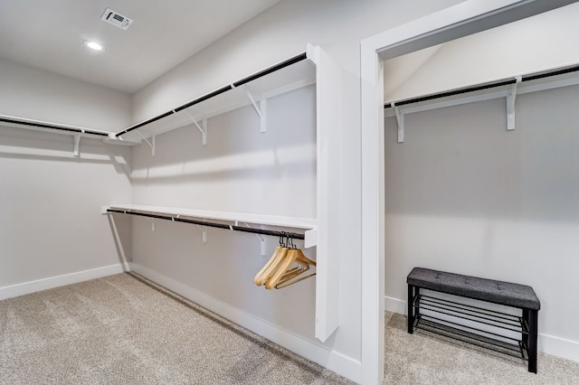 walk in closet featuring light colored carpet