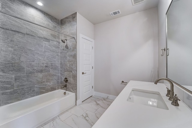 bathroom with vanity and tiled shower / bath