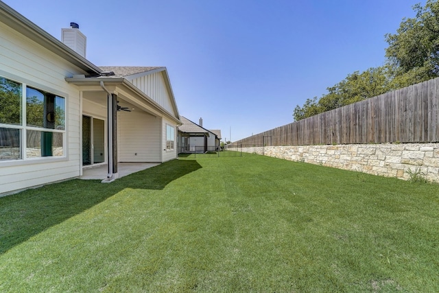 view of yard with ceiling fan and a patio