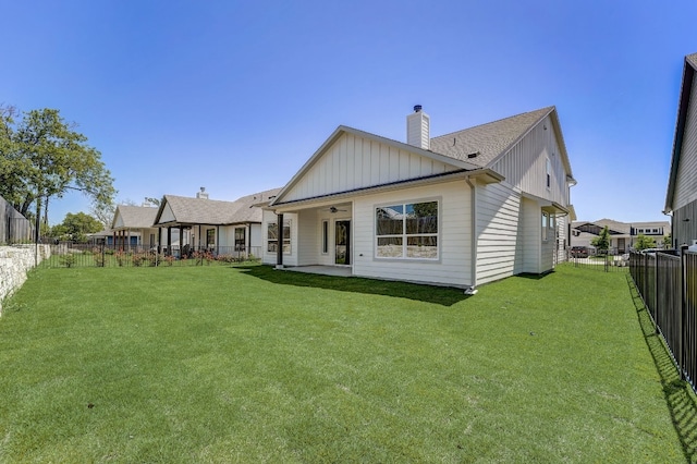 rear view of house with a yard, ceiling fan, and a patio area