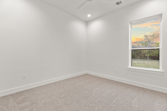 carpeted spare room featuring ceiling fan