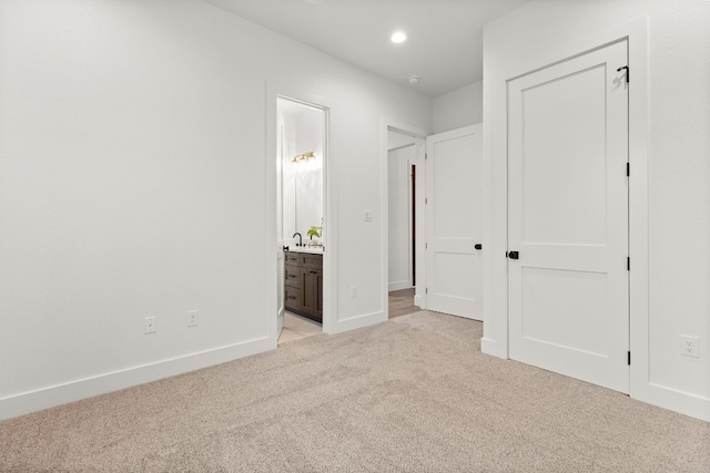 unfurnished bedroom featuring connected bathroom and light colored carpet